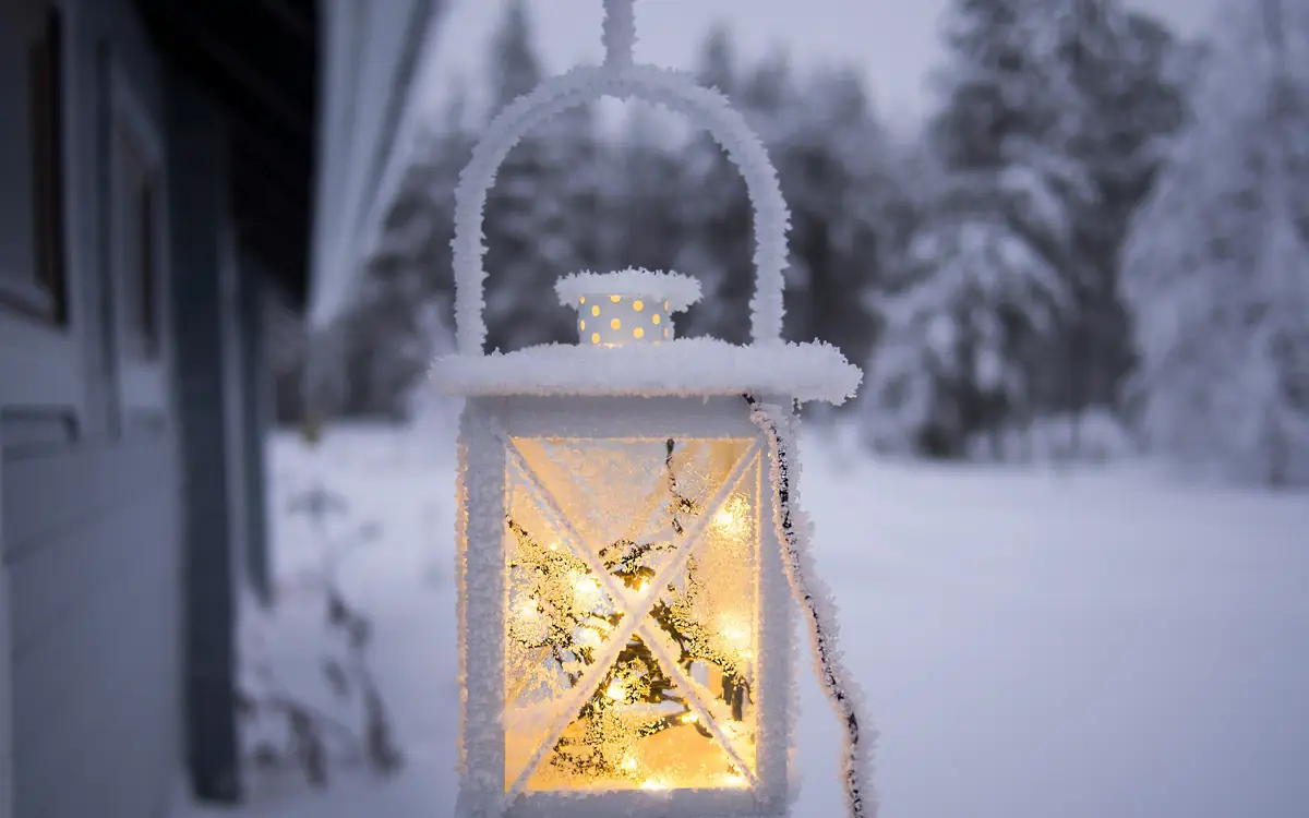 A frost-covered lantern glowing above the snow.
