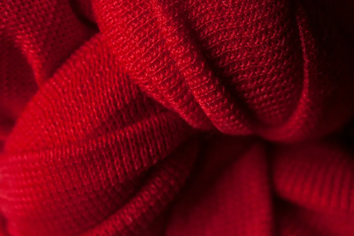 Gros plan d'un tricot de laine rouge aux plis profonds.